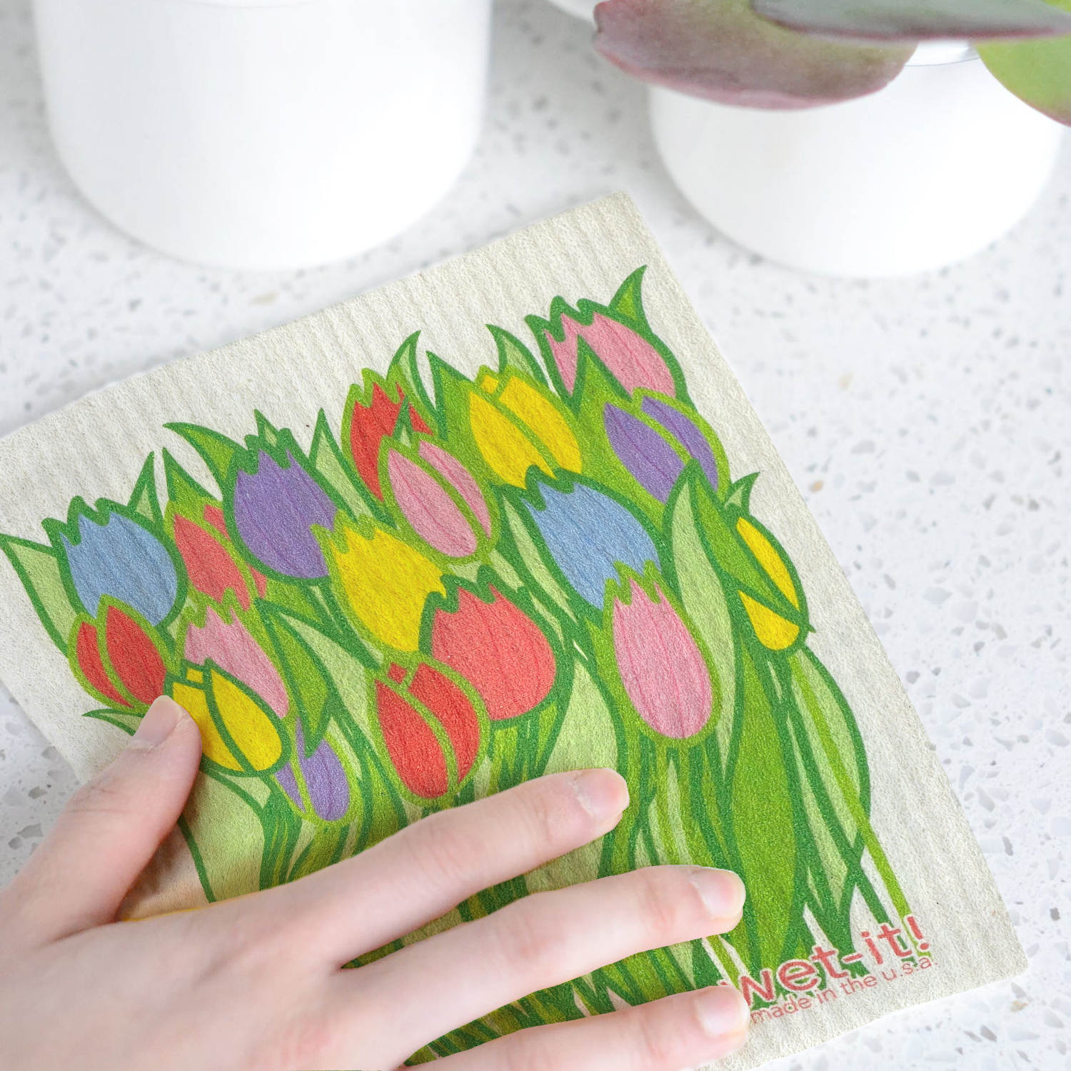 Picture of a hand cleaning a counter with tulip wet-it cloth